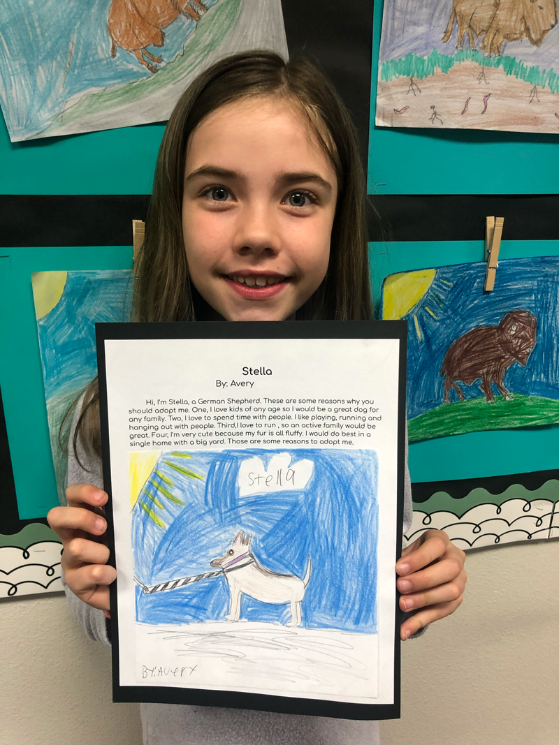 Student with paragraph and drawing of animal for adoption