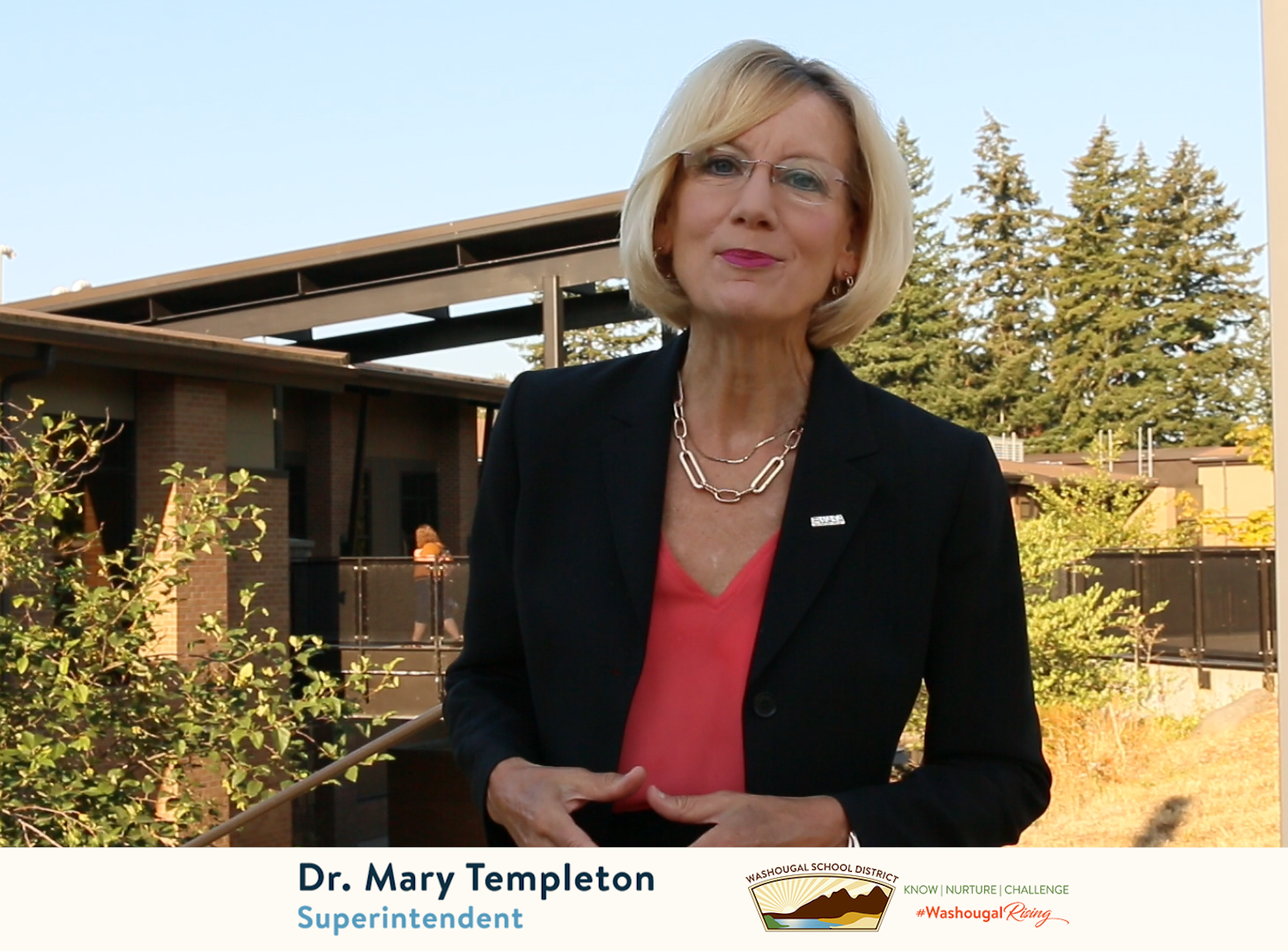 Woman in black suit with blonde hair standing in middle of frame facing camera. Caption bar reads "Dr Mary Templeton, Superintendent."