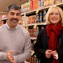 Camas Superintendent John Anzalone and Washougal Superintendent Mary Templeton smile, standing side-by-side in front of the canned food aisle at Safeway grocery store.
