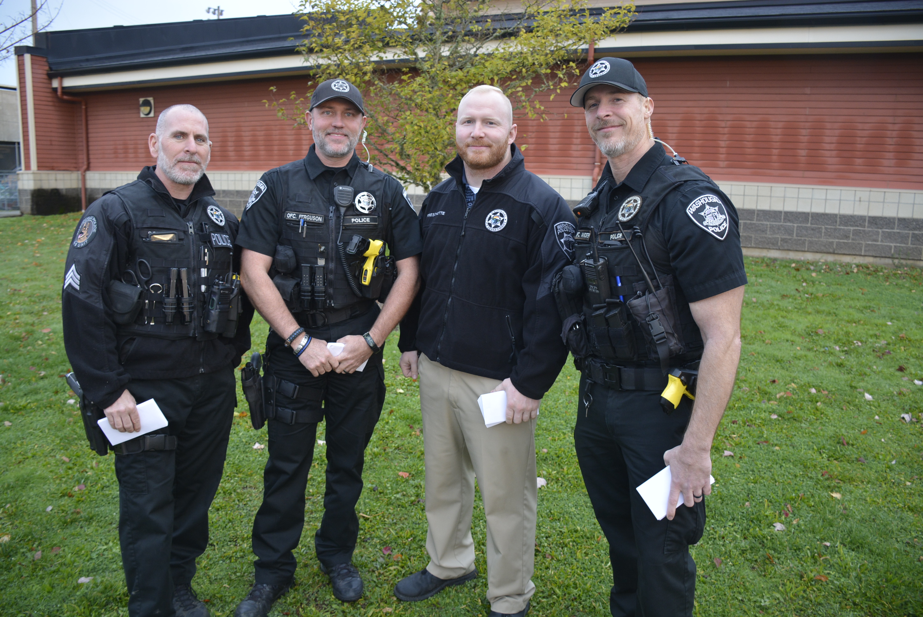 Four members of the Washougal Police Department standing near the school