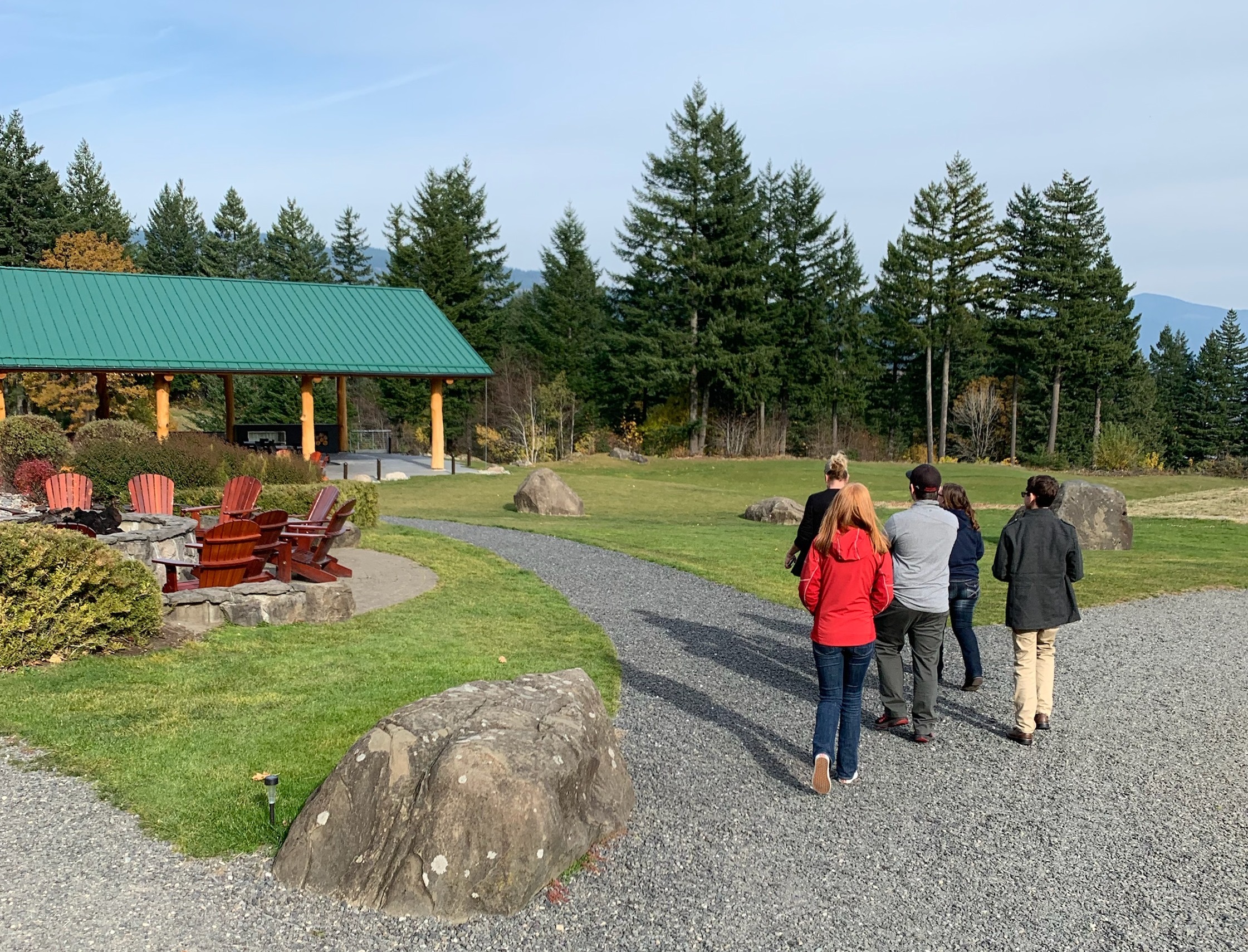 Group of students touring the campus of the Skamania Lodge with trees and event gazebo in the background