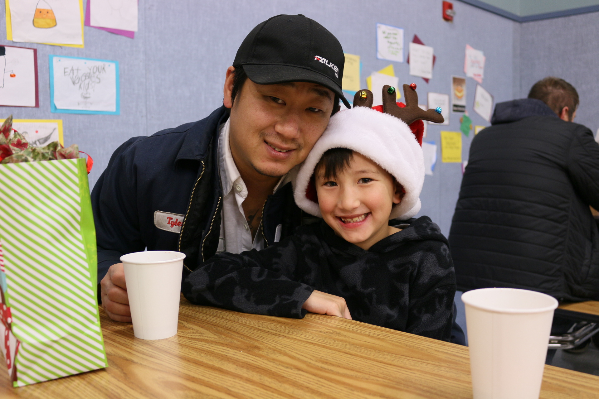 Photo of a father and son with hot chocolate sitting at a table in the Gause cafeteria