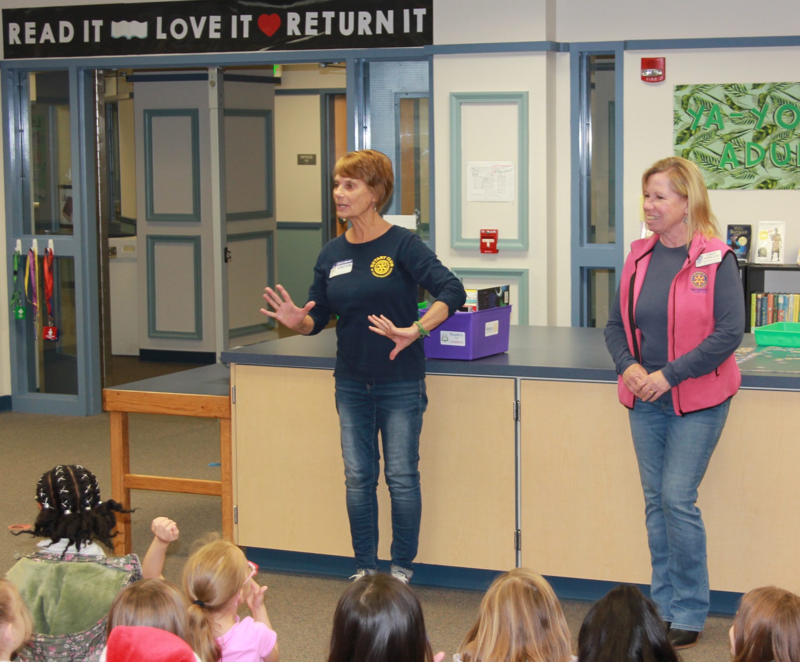 Rotarians talk about the Rotary Club to Gause students while presenting new classroom reading materials