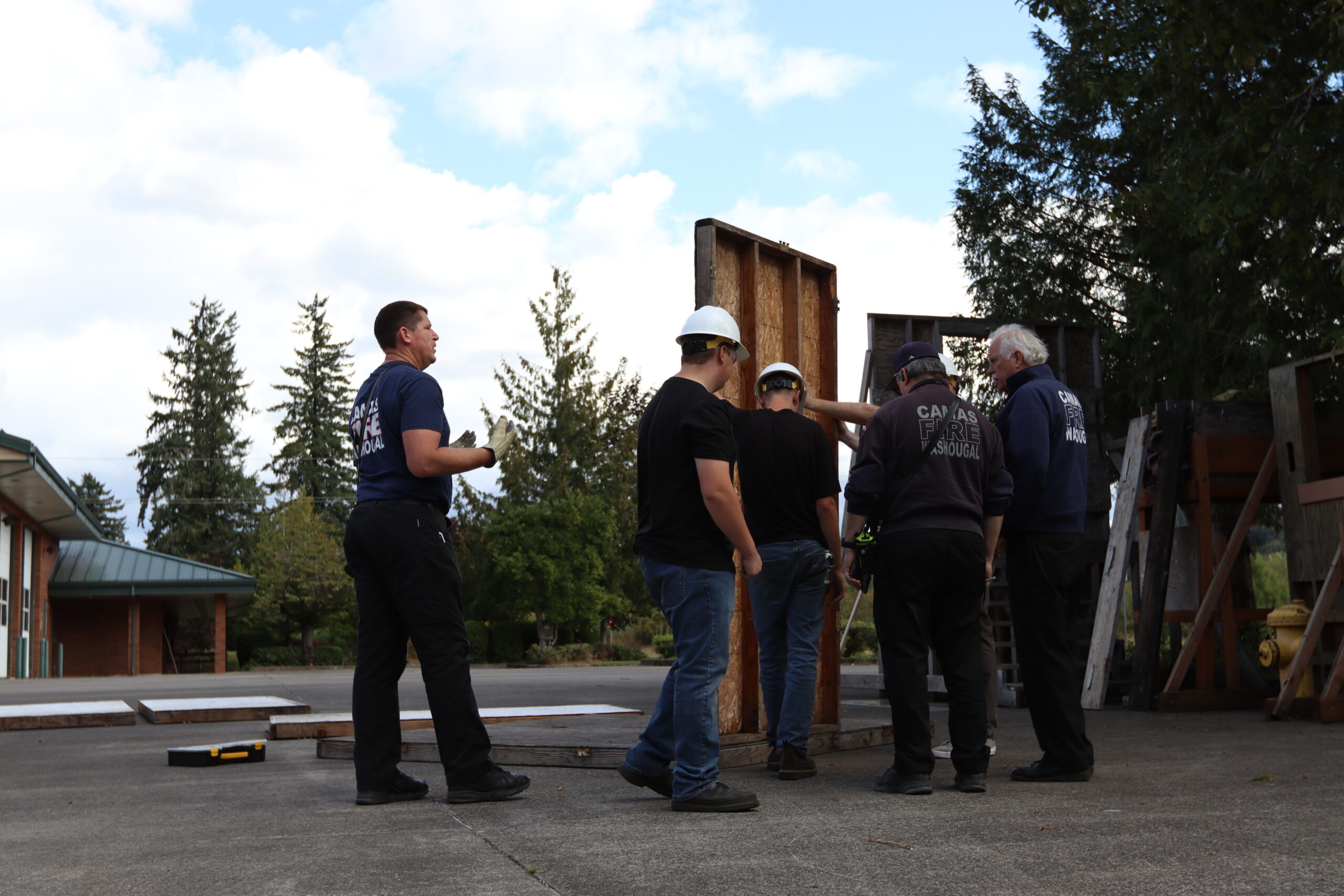 Students assemble walls while constructing room for fire safety demonstration 