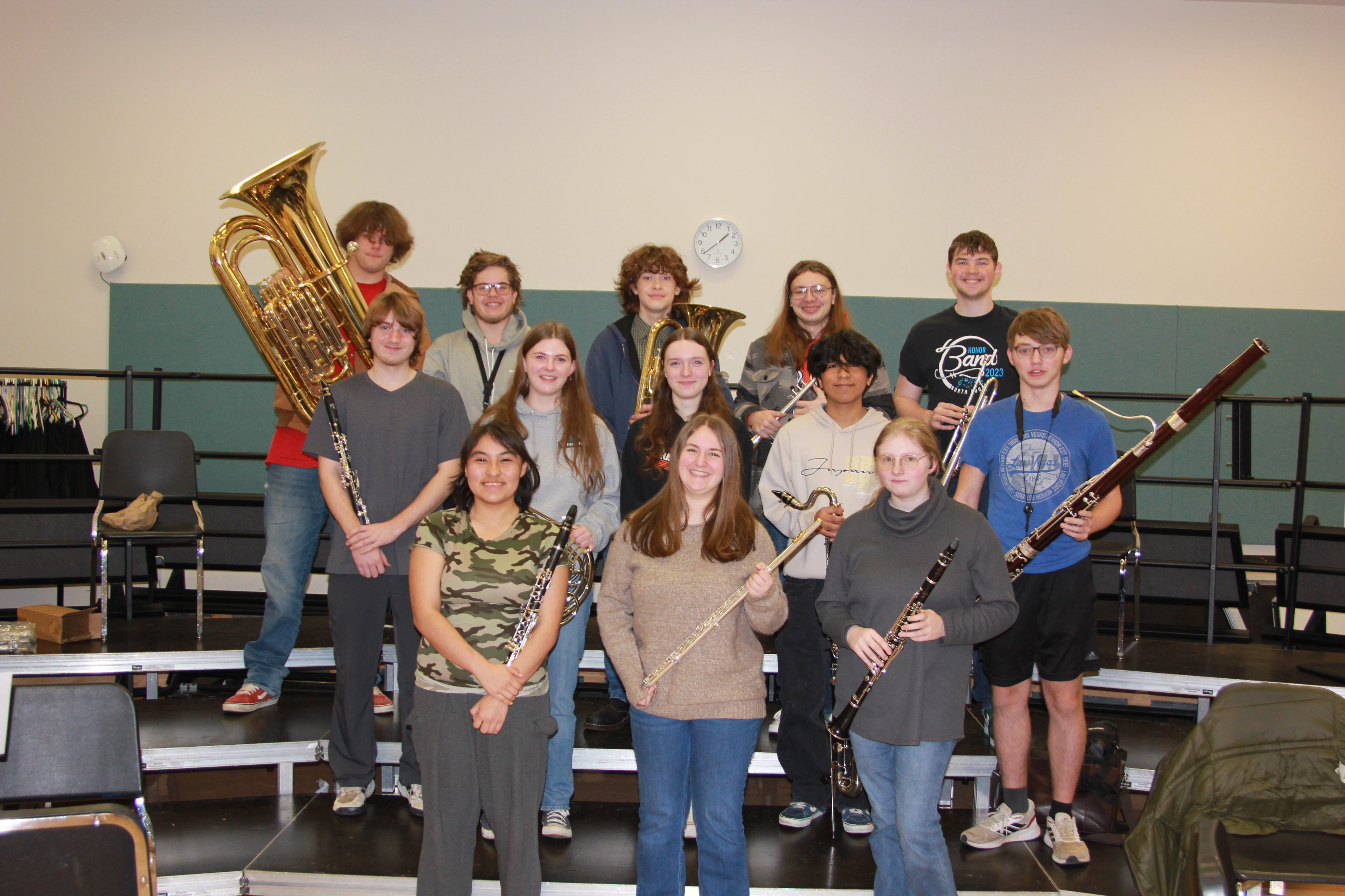 students pose with their instrument in the choir room