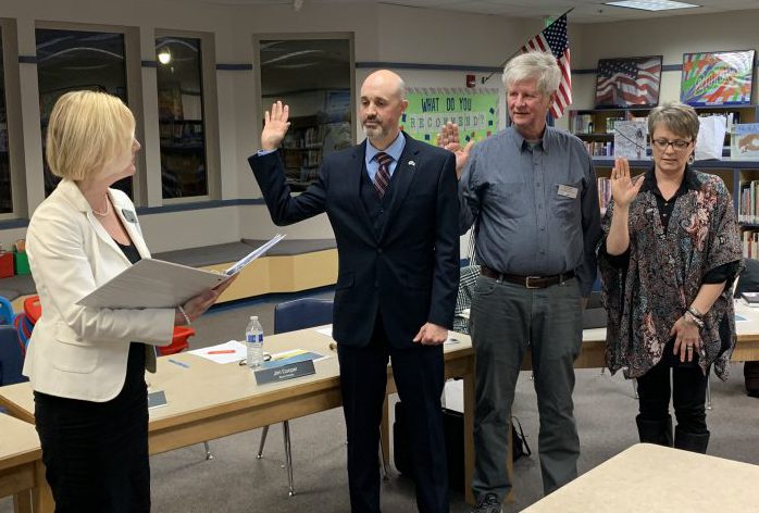 Superintendent Mary Templeton administers the oath of office for board member Cory Chase, Jim Cooper, and Angela Hancock in the Gause Library