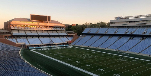 Picture of a stadium with the sun reflecting off the windows at the far end