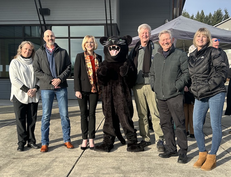 School board members pose with superintendent and WHS Panther mascot in front of Excelsior building at Washougal High