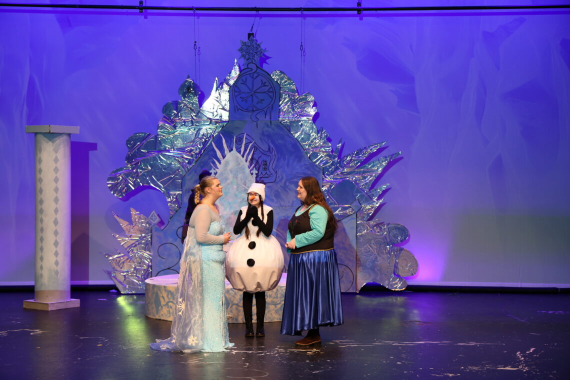 Elsa, Olaf, and Anna in front of an ice throne